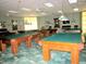 Spacious billiard room featuring multiple wooden pool tables at 9509 Se 124Th Loop, Summerfield, FL 34491