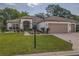 Well-maintained single-story home featuring a brick driveway and lush landscaping at 9509 Se 124Th Loop, Summerfield, FL 34491