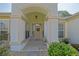 Welcoming front entrance with a decorative wreath and tiled walkway to the front door at 9509 Se 124Th Loop, Summerfield, FL 34491