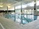 Indoor swimming pool with lane markers, handrails and large windows at 9509 Se 124Th Loop, Summerfield, FL 34491