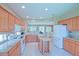 Open kitchen featuring an island with wine rack, white appliances, granite countertops and plenty of natural light at 9509 Se 124Th Loop, Summerfield, FL 34491