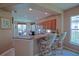 Open kitchen with granite countertops, wooden cabinets, and counter seating with dining area view at 9509 Se 124Th Loop, Summerfield, FL 34491