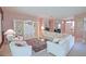 Open living room with plush white seating, decorative furnishings and a view to the entry foyer at 9509 Se 124Th Loop, Summerfield, FL 34491