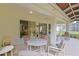 Cozy screened patio features tile flooring, a ceiling fan, and access to the beautifully landscaped backyard at 9509 Se 124Th Loop, Summerfield, FL 34491