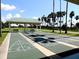 Community shuffleboard court featuring a covered pavilion and lined by palm trees at 9509 Se 124Th Loop, Summerfield, FL 34491