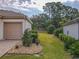 Side yard showing grass and stone landscaping of this single-Gathering home at 9509 Se 124Th Loop, Summerfield, FL 34491
