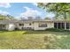Grassy backyard features a screened lanai, bench, and lush landscaping at 9820 Sw 89Th Ter # B, Ocala, FL 34481