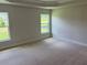 Spacious main bedroom featuring two windows that fill the room with natural light and plush carpeting at 2166 Nw 23Rd Loop, Ocala, FL 34475