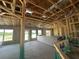 Open-concept interior with visible framing, insulation, concrete floor, and exterior views at 4522 Sw 90Th Lane Rd, Ocala, FL 34476