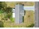 Drone shot of the home's roof, long driveway, and back patio area with outdoor seating at 10190 Se 178Th St, Summerfield, FL 34491