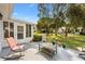 Back patio with cozy seating and colorful planters, set against a well-kept lawn and mature trees at 10190 Se 178Th St, Summerfield, FL 34491