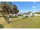 Fenced backyard and well-maintained lawn. The house is white with a grey roof at 10190 Se 178Th St, Summerfield, FL 34491