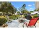 Backyard patio area with outdoor seating, a black grill, and well-maintained lawn and landscaping at 10190 Se 178Th St, Summerfield, FL 34491