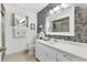 Bright bathroom with floral wallpaper, well-lit vanity, mirror, and a shower-tub combination at 10190 Se 178Th St, Summerfield, FL 34491