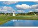 Picturesque community featuring a decorative lighthouse and a tranquil pond surrounded by lush greenery at 10190 Se 178Th St, Summerfield, FL 34491