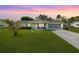 Charming single-story home with a well-manicured lawn and a screened-in garage at dusk at 10190 Se 178Th St, Summerfield, FL 34491
