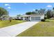 Beautiful one-story home with a long driveway, screened garage, and pristine lawn at 10190 Se 178Th St, Summerfield, FL 34491