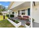 Inviting front porch with seating, colorful flowers, and charming details at 10190 Se 178Th St, Summerfield, FL 34491
