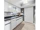Charming kitchen features stainless steel sink, black countertops, and white cabinets, illuminated by a skylight at 10190 Se 178Th St, Summerfield, FL 34491