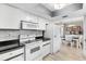 Bright kitchen boasts white appliances, subway tile backsplash, and open access to the dining area at 10190 Se 178Th St, Summerfield, FL 34491