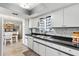 Well-maintained kitchen featuring black countertops, subway tile, stainless steel sink, and dining area access at 10190 Se 178Th St, Summerfield, FL 34491
