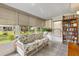 Bright sunroom with lots of windows, a floral sofa, and a bookshelf with lots of books at 10190 Se 178Th St, Summerfield, FL 34491
