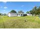 Expansive backyard featuring a lush green lawn, fenced perimeter, and the rear view of the home at 10385 Se 178Th St, Summerfield, FL 34491