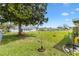 Spacious backyard featuring a well-manicured lawn, mature trees, and a charming pink bench at 10385 Se 178Th St, Summerfield, FL 34491