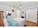 Bedroom with laminate floors, neutral walls, ceiling fan and adjacent bathroom for convenience at 10385 Se 178Th St, Summerfield, FL 34491