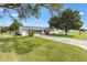 One-story home boasts a well-kept lawn, mature trees, and a screened garage, offering both curb appeal and practicality at 10385 Se 178Th St, Summerfield, FL 34491