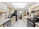 Well-lit kitchen showcasing white tile floors and white cabinetry with wooden trim and black appliances at 10385 Se 178Th St, Summerfield, FL 34491