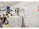 Functional laundry room with washer, dryer, storage shelves, and convenient access door at 10385 Se 178Th St, Summerfield, FL 34491