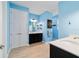 Bright, modern bathroom with blue walls, double vanities, and a separate water closet at 10445 Sw 90Th Street Rd, Ocala, FL 34481