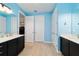 Bathroom showcasing dual vanities, blue walls, and a separate water closet for added privacy at 10445 Sw 90Th Street Rd, Ocala, FL 34481