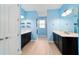 Dual vanity bathroom featuring blue walls, lots of counter space and wood tile flooring at 10445 Sw 90Th Street Rd, Ocala, FL 34481