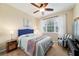Cozy bedroom featuring a patterned bedspread, side tables, and an accent chair by the window at 10445 Sw 90Th Street Rd, Ocala, FL 34481