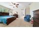 Relaxing bedroom with dark wood furnishings, a comfortable recliner, and an ensuite bathroom at 10445 Sw 90Th Street Rd, Ocala, FL 34481