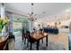 Dining room with modern light fixture leading to a kitchen and an outdoor living area at 10445 Sw 90Th Street Rd, Ocala, FL 34481