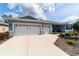 Charming single-story home with a two-car garage and beautifully landscaped front yard and walkway at 10445 Sw 90Th Street Rd, Ocala, FL 34481