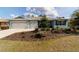 Charming home featuring a well-manicured lawn, beautiful landscaping, and a three-car garage at 10445 Sw 90Th Street Rd, Ocala, FL 34481