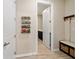 Hallway with a spice rack, a bench and door that leads to a room with a dark vanity at 10445 Sw 90Th Street Rd, Ocala, FL 34481