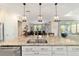 Open-concept kitchen features stainless steel sink with granite countertops and pendant lighting at 10445 Sw 90Th Street Rd, Ocala, FL 34481