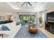 Open-concept living room with wood-look tile flooring, stylish decor, and access to the screened lanai at 10445 Sw 90Th Street Rd, Ocala, FL 34481