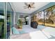 Inviting screened porch featuring comfortable seating, ceiling fan and backyard view, perfect for outdoor living at 10445 Sw 90Th Street Rd, Ocala, FL 34481