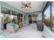 Cozy screened porch with furniture and ceiling fan, offering outdoor space with pleasant views of backyard at 10445 Sw 90Th Street Rd, Ocala, FL 34481
