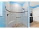 Modern glass-enclosed shower featuring a tiled bench, river rock floor and striking blue walls at 10445 Sw 90Th Street Rd, Ocala, FL 34481