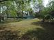 Large backyard features a line of trees and a tennis court in the background at 10955 Sw 89Th Ave, Ocala, FL 34481