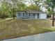 Well-maintained single-story home featuring blue siding, a one-car garage, and a landscaped front yard with mature trees at 10955 Sw 89Th Ave, Ocala, FL 34481