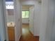 Hallway view showcases wood floors and leads to a bathroom and bedroom at 10955 Sw 89Th Ave, Ocala, FL 34481