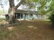 View of home's back, showcasing the screened-in porch and large backyard at 10955 Sw 89Th Ave, Ocala, FL 34481